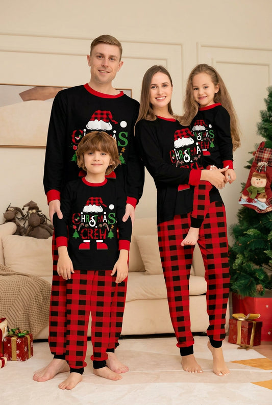 Famille en pyjamas de Noël assortis, hauts noirs à inscription Christmas Crew et pantalons à carreaux rouges et noirs. 
