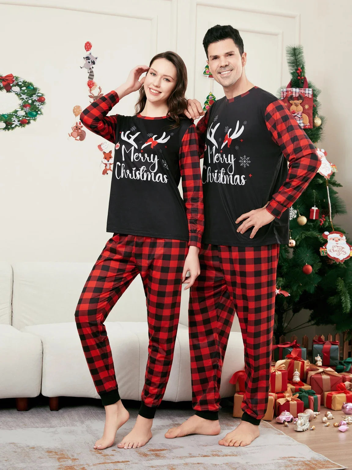 Couple en pyjamas de Noël assortis à carreaux rouges et noirs, avec inscription Merry Christmas sur les hauts.